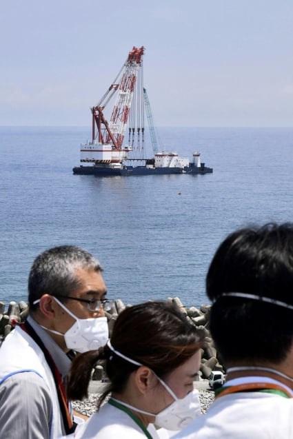 A work ship is seen offshore where the Tokyo Electric Power Company says it has installed  the last piece of an undersea tunnel to be used to release treated radioactive wastewater, during a media tour of the Fukushima Daiichi nuclear power plant in northern Japan on June 26. Photo: AP